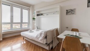 A minimalist bedroom with a bed, a small table, and a chair. - Italianway Easy - Biancamano 2 (Milan)