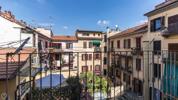 A courtyard with buildings, a metal fence, and a clear sky. - Italianway Comfort - Borsieri 11 B (Milan)