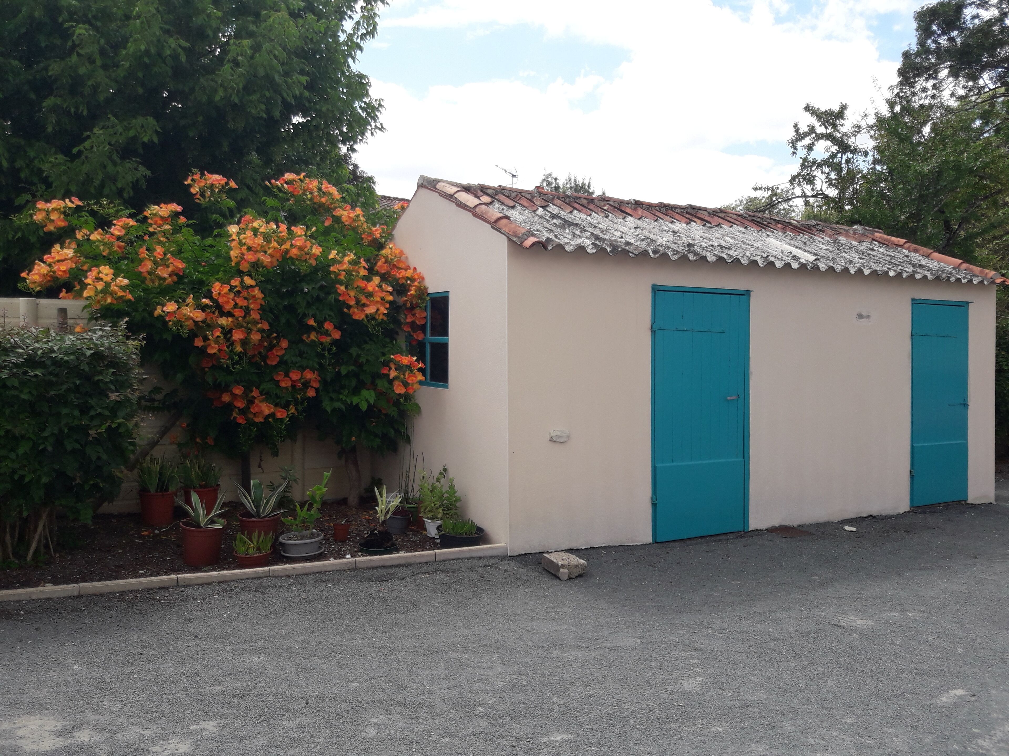 Un piccolo edificio con tetto in lamiera ondulata e due porte blu.
