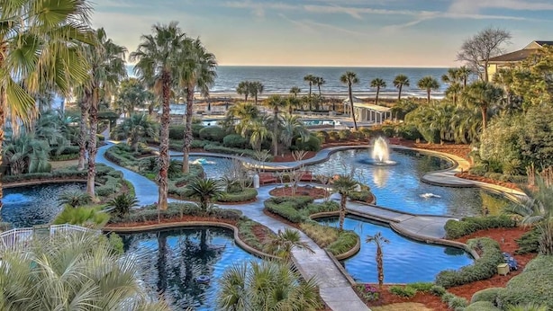 A resort with multiple swimming pools, palm trees, and a view of the ocean. - Oceanfront Villa w/Pool Beach Access Hilton Head (Hilton Head Island)