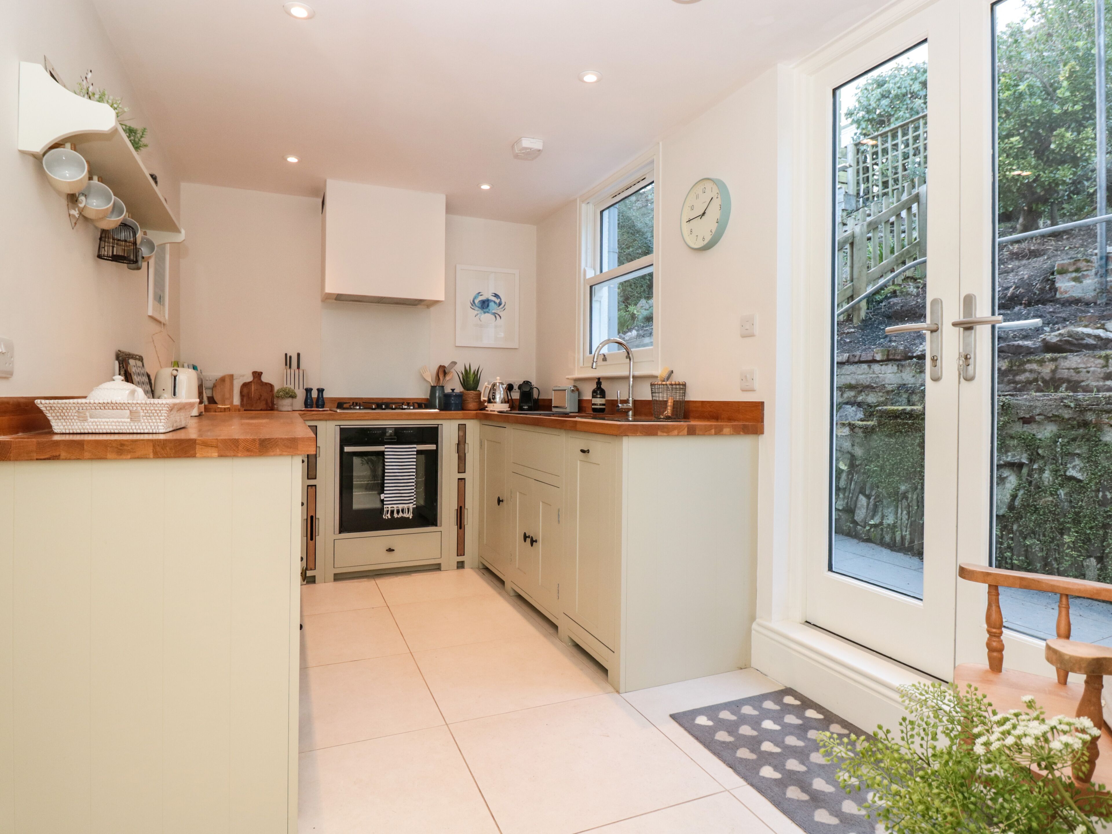A kitchen with a built-in oven, a sink, and a window.