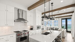 Una cocina moderna con armarios blancos, electrodomésticos de acero inoxidable y una isla grande.