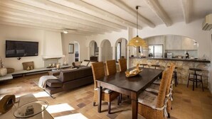Ein geräumiger Wohnbereich mit Esstisch, Sofas und einer Küche im Hintergrund.