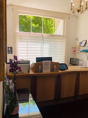 A reception desk with a computer, printer, and a sign indicating no smoking. - Albany, Brighton & Hove (Hove)