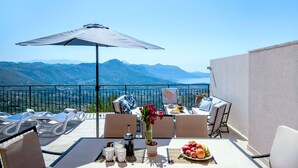 Una terraza con una mesa dispuesta para el desayuno, con vistas a un paisaje montañoso.