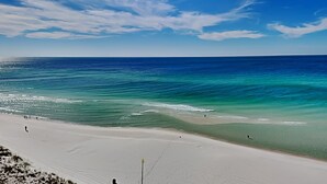 Una playa con aguas azules cristalinas y una orilla arenosa.