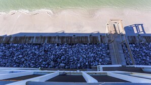 A wooden pier leading to a beach with a rocky shoreline. - Beachfront, Bayview, Relax ~ Edgewater Retreat (Cape San Blas)