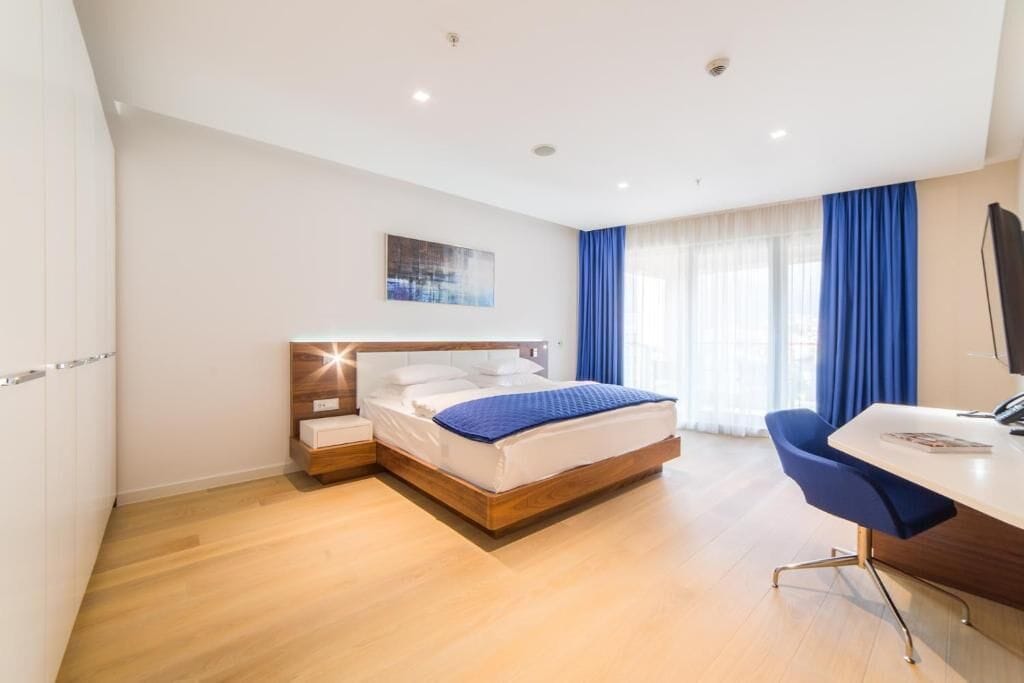 Una habitación de hotel moderna con una cama de madera, un escritorio y una silla.