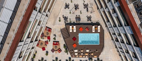 Área de piscina no terraço com vários espaços para sentar e uma piscina central.