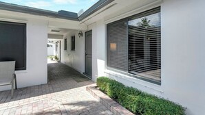 A clean, modern building with a covered walkway, large windows with blinds, and a well-maintained exterior. - Beautiful 1bd, prime location, free parking, bbq, pets (Delray Beach)