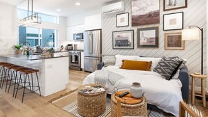 Una cocina moderna con una isla central, taburetes de bar y un comedor.