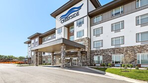 A multi-story hotel with a stone facade and a covered entrance. - Holiday Inn Express Kansas City North – Parkville by IHG (Parkville)