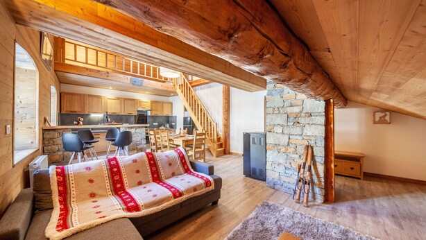 A cozy loft bedroom with a wooden ceiling, a stone wall, and a staircase leading to a kitchen. - LA RECHASSE - Proche des pistes (Termignon)