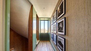 A hallway with wooden flooring, a sloped ceiling, and framed pictures on the walls. - Sintra Green Chalet - Bed & Breakfast (Sintra)