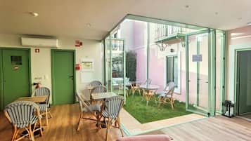 A room with a dining area, a small garden, and a glass partition.