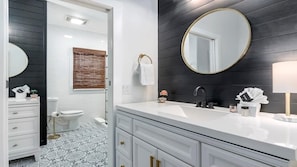 Bathtub, hair dryer, towels, shampoo