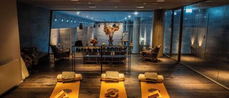 Un spa moderno con suelos de madera, una recepción y un muro de vidrio.