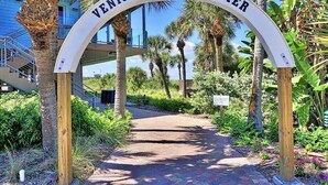 A sign reading "Venice Fishing Pier" with a pathway leading through a tropical garden. - 🏝️PET FRIENDLY 3-bedroom house, minutes from Beach,Heated Pool (Venice)