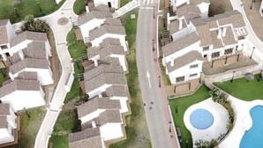Un quartier résidentiel avec des maisons, une rue principale et deux piscines.