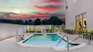 A swimming pool with lounge chairs and a sign prohibiting diving.