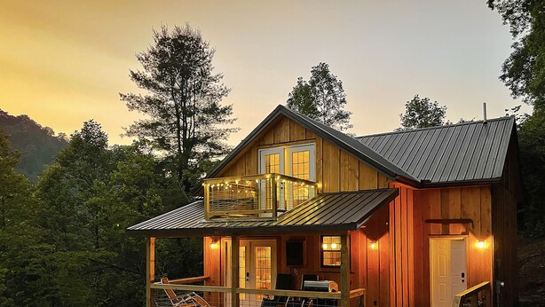 Une cabane en bois dotée d’un balcon, d’une véranda et d’un escalier menant à l’entrée.