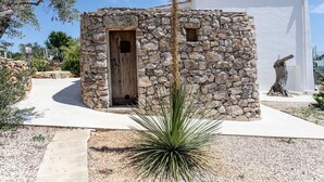A stone building with a wooden door, surrounded by gravel and a yucca plant. - Villa Torre Dell'alto mare Blocco n.2 (Alliste)