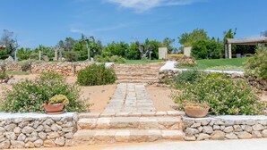 A stone pathway leading to a gazebo, surrounded by potted plants and a stone wall. - Villa Torre Dell'alto mare Blocco n.2 (Alliste)