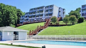Ein Poolbereich mit einem kleinen Gebäude, einer Treppe und einem mehrstöckigen Gebäude im Hintergrund.