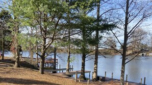 A lakeside park with wooden benches and a dock extending into the water. - Beautiful Reelfoot Lake (Tiptonville)