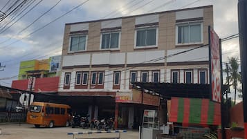 A multi-story building with a ground-level commercial space and a hotel on the upper floor.