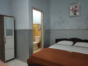 A room with a bed, a wardrobe, and a bathroom visible through an open door. - OYO 90529 Hotel Baruga Makassar (Marusu)