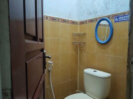 Un baño pequeño con inodoro, ducha y espejo.
