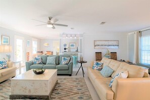 A living room with two sofas, a coffee table, and a ceiling fan.