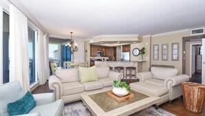 Ein Wohnzimmer mit Sofa, Couchtisch und Blick zur Küche.