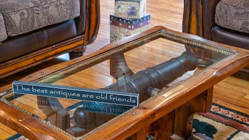 A wooden table with a glass top and a sign that reads "The best antiques are old friends."