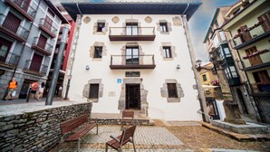 A hotel with a white facade, multiple balconies, and a stone entrance. - Hotel Branka (Mundaka)
