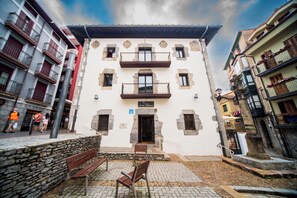 A hotel with a white facade, multiple balconies, and a stone entrance. - Hotel Branka (Mundaka)