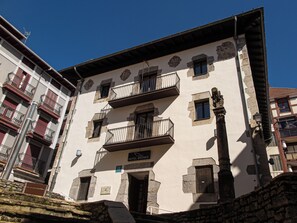 A multi-story building with balconies, a sign indicating it is a hotel, and stone architectural details. - Hotel Branka (Mundaka)