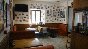 A restaurant with wooden booths, tables, and a wall decorated with numerous small pictures. - Hotel Branka (Mundaka)