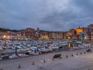 A marina filled with boats, surrounded by historic buildings with a prominent tower. - Hotel Branka (Mundaka)