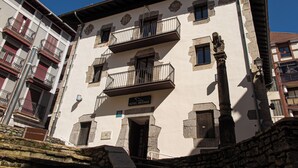A multi-story building with balconies, a sign indicating it is a hotel, and stone architectural details. - Hotel Branka (Mundaka)