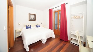 A bedroom with a bed, a nightstand, a chair, a wardrobe, and a door. - Hotel Branka (Mundaka)