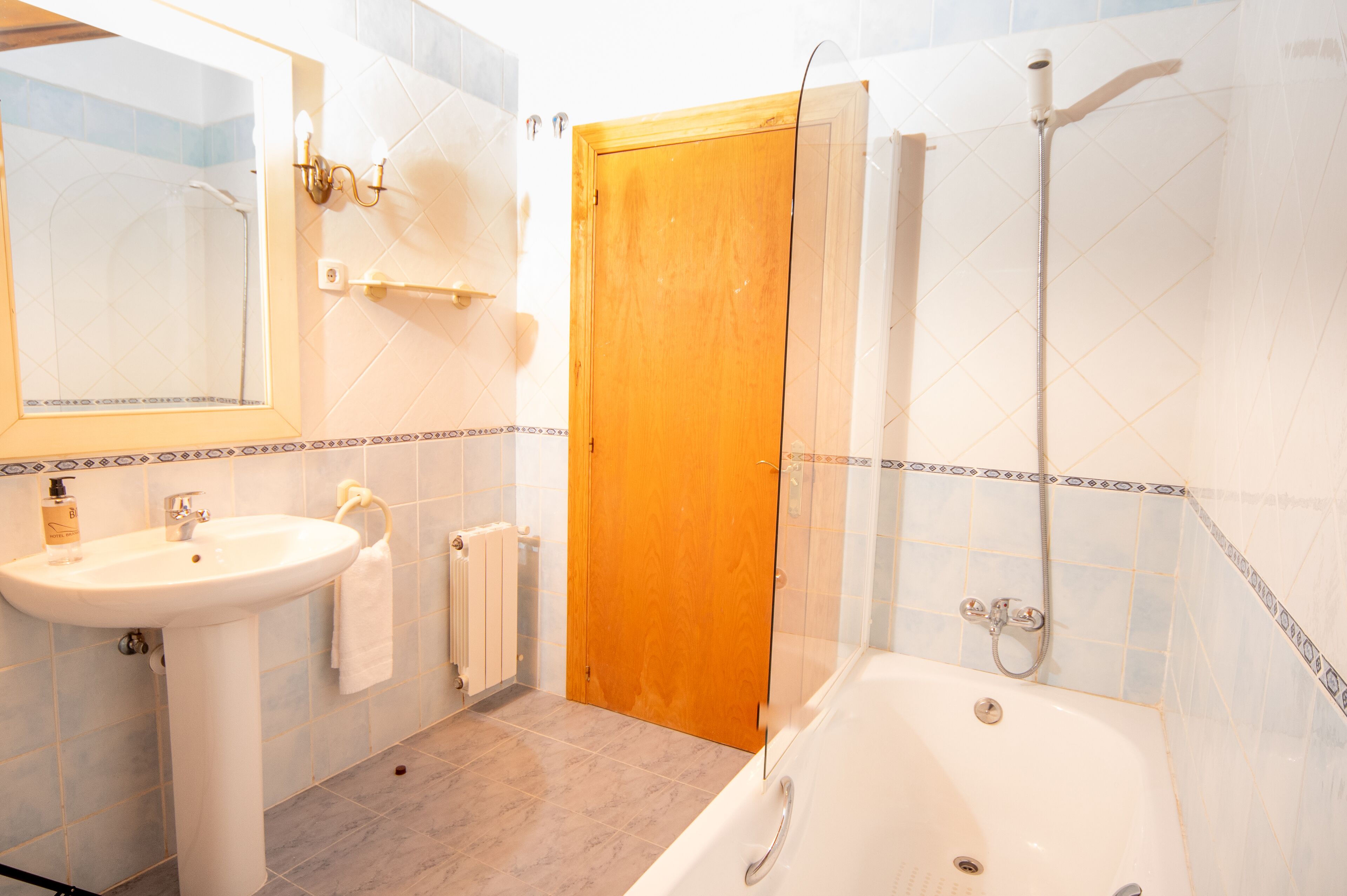 Un baño con lavamanos, espejo, ducha y bañera.