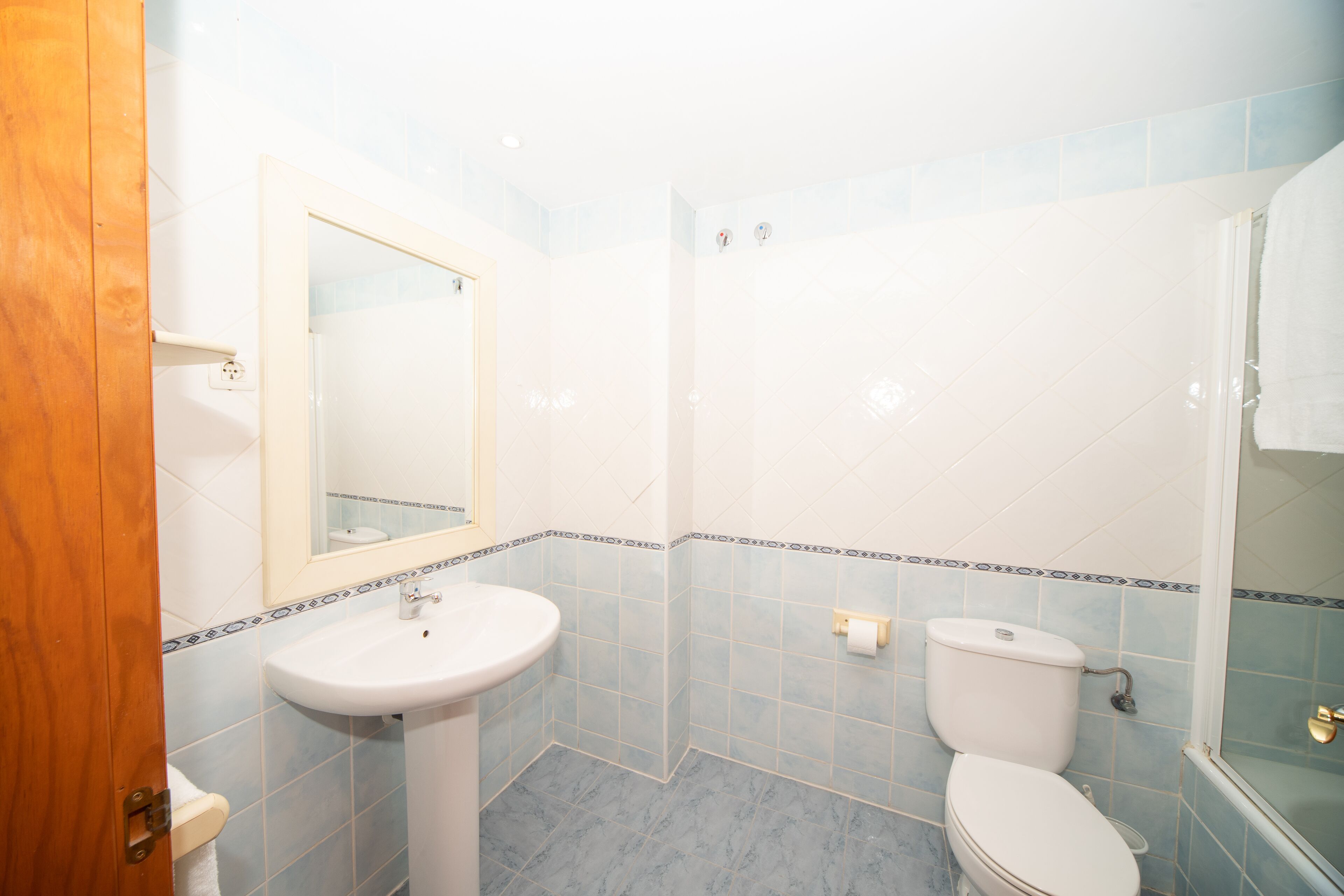 Une salle de bain avec un lavabo, des toilettes et un miroir.