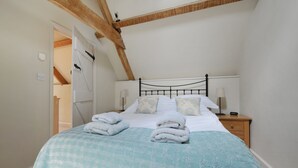 A bedroom with a bed, a nightstand, and a wooden ceiling beam. - The Barn, Park Farm near Chew Magna, Bristol (Bristol)