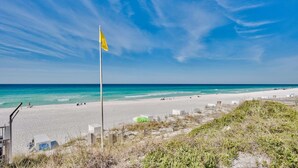 A beach with a flag, clear blue sky, and ocean. - Hidden Dunes Beach Cottage 167- Private Beach Access!- Heated Pool (Miramar Beach)