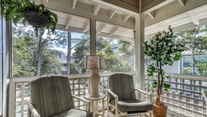 A covered porch with two upholstered chairs, a floor lamp, and a potted tree. - Hidden Dunes Beach Cottage 167- Private Beach Access!- Heated Pool (Miramar Beach)