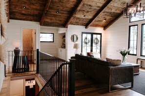 Relax in this stylish space with a sofa, staircase, and elegant touches.