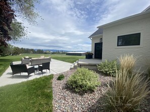 Relax in the serene outdoor space, complete with a patio, wicker chairs, and a table.