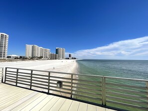 A beach with a wooden boardwalk and buildings in the background. - Four Seasons 804W 2 King beds Fishing Pier Read Parking Rules new flooring (Orange Beach)